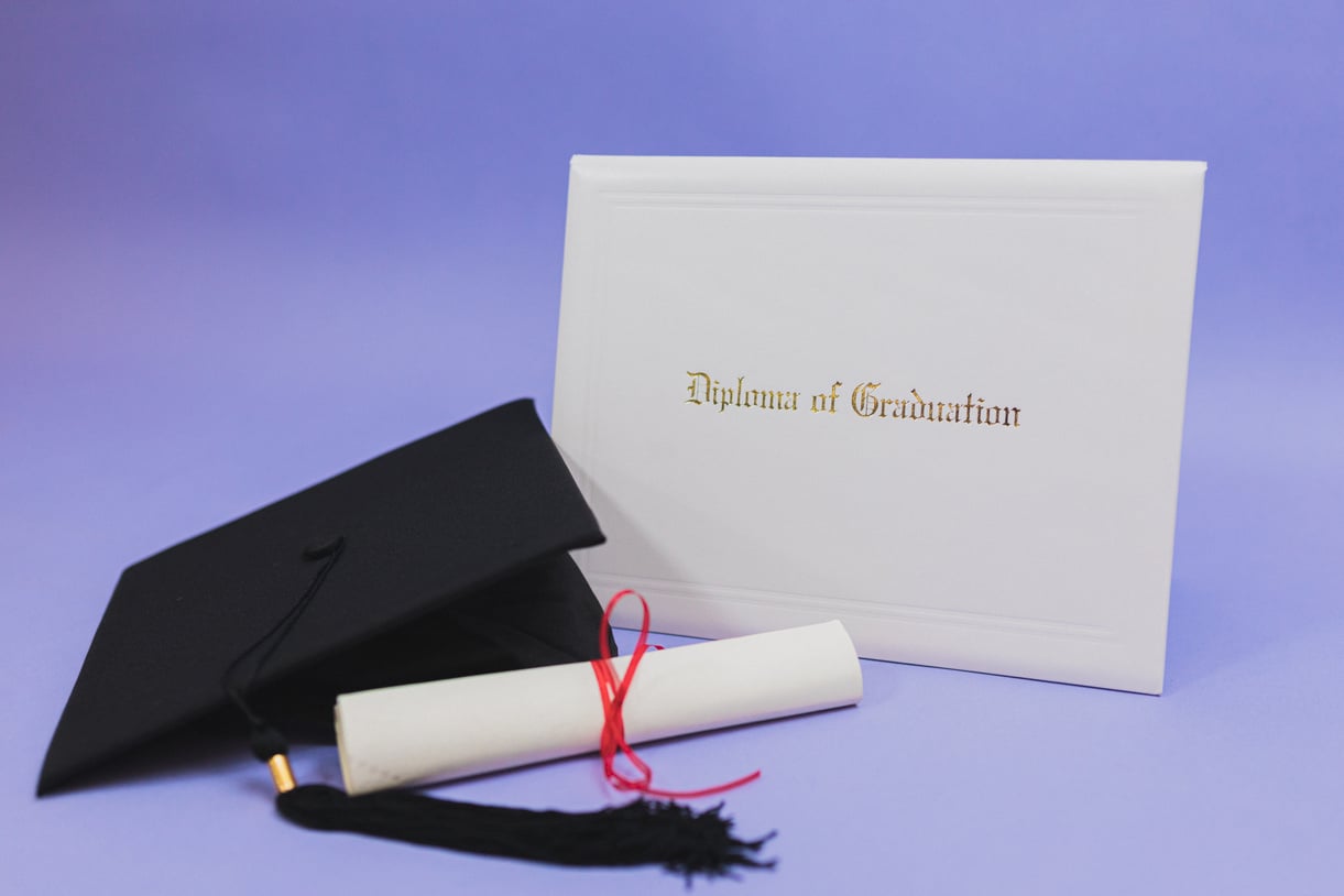 Diploma and Mortarboard on Purple Background